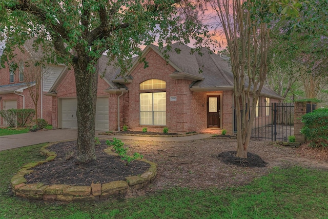 view of front facade with brick siding, driveway, an attached garage, and roof with shingles