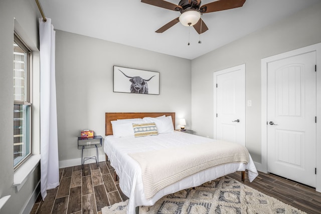 bedroom with ceiling fan, baseboards, and wood finish floors