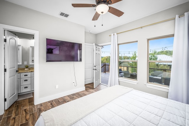 bedroom featuring baseboards, visible vents, dark wood-style floors, ensuite bath, and ceiling fan