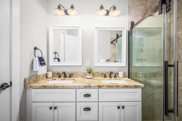 bathroom with double vanity, a shower stall, and a sink