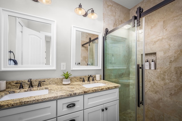 full bath featuring a shower stall, double vanity, and a sink