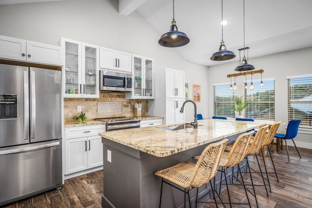 kitchen with tasteful backsplash, lofted ceiling with beams, appliances with stainless steel finishes, dark wood-style flooring, and a sink