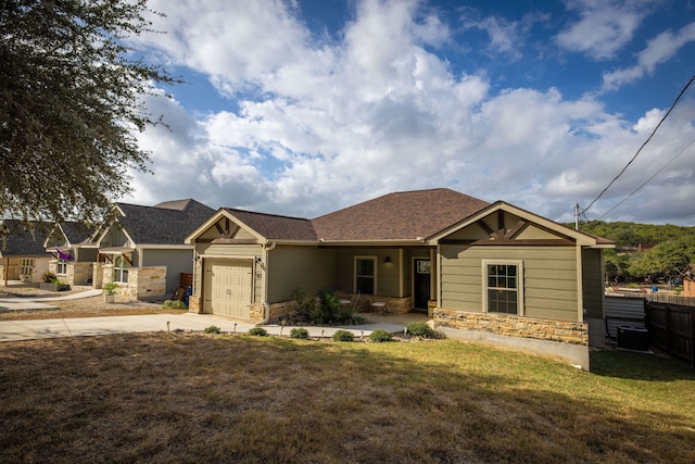 view of front of house with a garage, fence, stone siding, concrete driveway, and a front yard