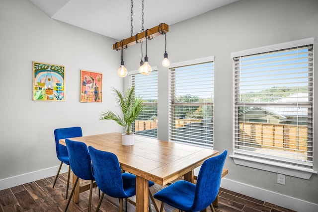 dining area featuring dark wood-type flooring and baseboards