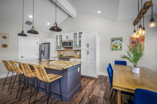 kitchen with visible vents, dark wood-type flooring, a sink, tasteful backsplash, and stainless steel appliances