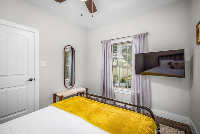 bedroom with ceiling fan, baseboards, and wood finished floors