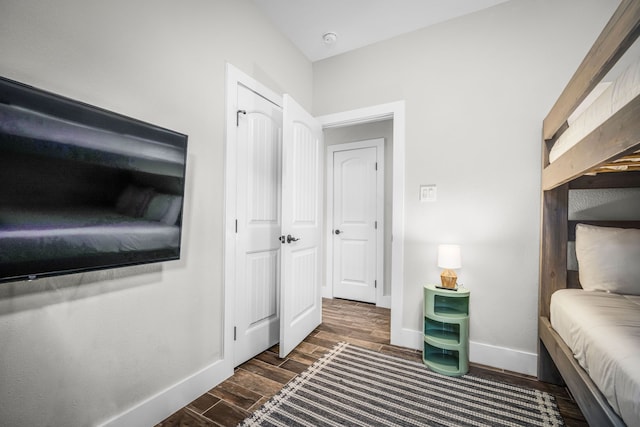 bedroom with dark wood finished floors and baseboards