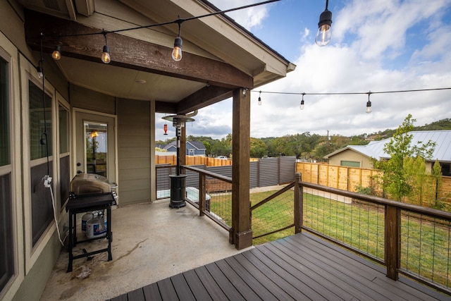 wooden deck featuring a yard, a fenced backyard, and a grill