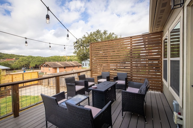 wooden terrace featuring an outdoor living space with a fire pit