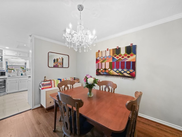 dining area with light wood-type flooring, wine cooler, baseboards, and crown molding