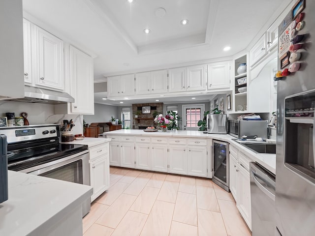 kitchen featuring wine cooler, stainless steel appliances, light countertops, white cabinets, and under cabinet range hood