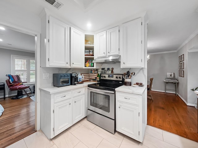 kitchen featuring crown molding, visible vents, white cabinets, stainless steel range with electric stovetop, and under cabinet range hood