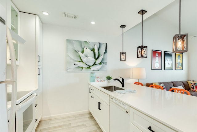 kitchen with recessed lighting, white appliances, a sink, visible vents, and light wood-type flooring