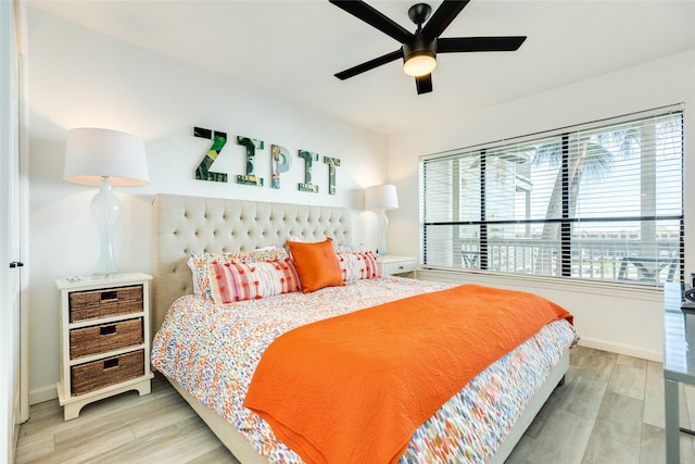 bedroom featuring ceiling fan, baseboards, and wood finished floors