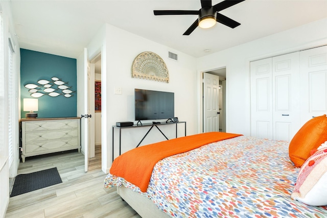 bedroom featuring a closet, visible vents, ceiling fan, and wood finished floors