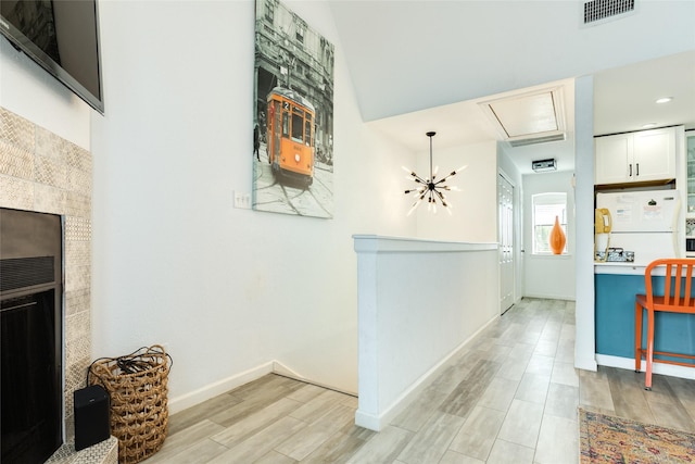 hallway with baseboards, visible vents, and wood finish floors