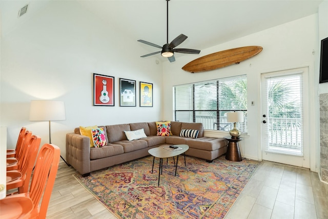 living room with ceiling fan, high vaulted ceiling, and visible vents