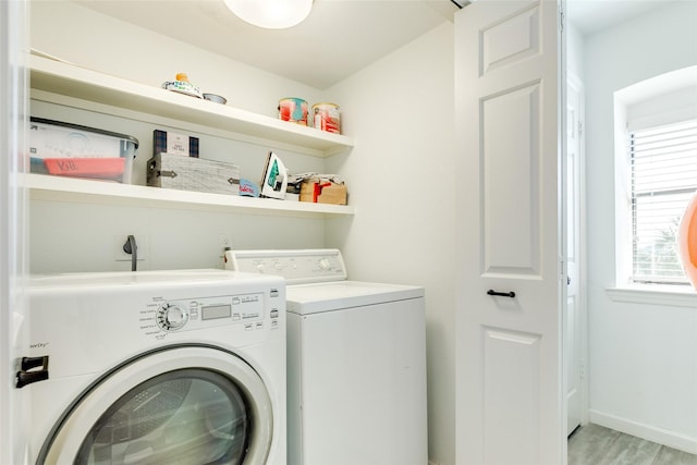 washroom featuring laundry area, light wood finished floors, washing machine and dryer, and baseboards