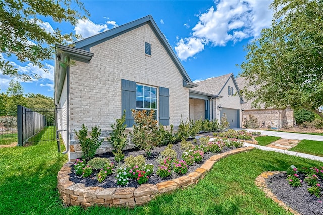 view of front of home with brick siding, fence, a garage, driveway, and a front lawn