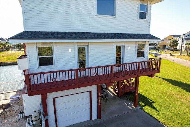 rear view of house featuring a garage, roof with shingles, a carport, and a yard