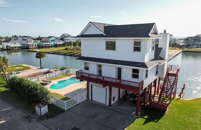 rear view of house featuring a fenced in pool, roof with shingles, stairway, a residential view, and a fenced backyard