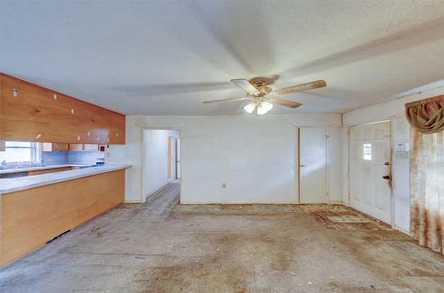 interior space featuring concrete floors, a textured ceiling, and ceiling fan