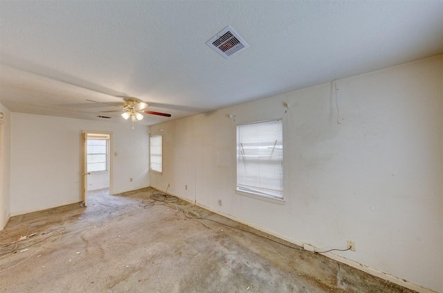 empty room featuring a textured ceiling, visible vents, and a ceiling fan