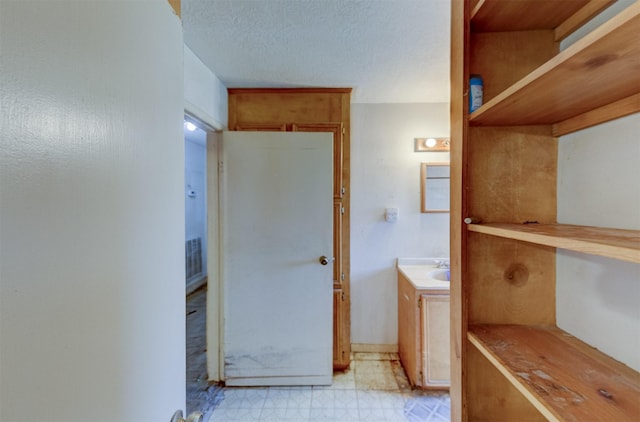 bathroom with visible vents, a textured ceiling, vanity, and tile patterned floors