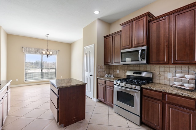 kitchen with light tile patterned flooring, stainless steel appliances, decorative light fixtures, backsplash, and a chandelier