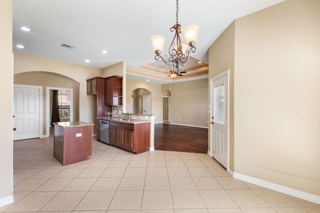 kitchen with light tile patterned floors, arched walkways, dishwasher, a raised ceiling, and a notable chandelier