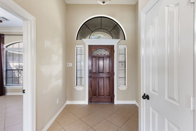 entryway with light tile patterned floors, visible vents, baseboards, and ornamental molding