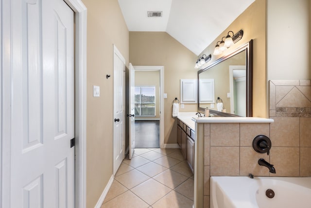 bathroom with vanity, visible vents, vaulted ceiling, tile patterned floors, and a washtub