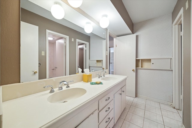 full bathroom with double vanity, tile patterned flooring, and a sink