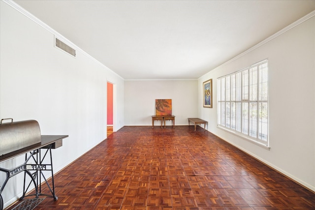 spare room featuring ornamental molding, visible vents, and baseboards