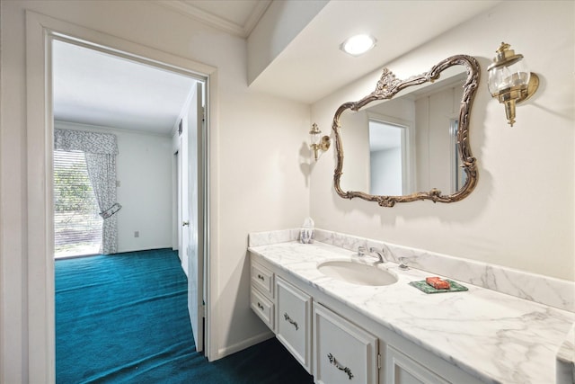 bathroom featuring baseboards, crown molding, and vanity