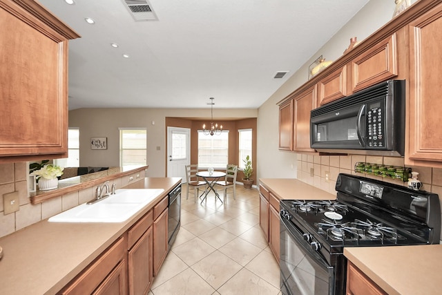 kitchen with tasteful backsplash, light countertops, visible vents, a sink, and black appliances