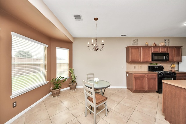 kitchen featuring black appliances, tasteful backsplash, visible vents, and light countertops