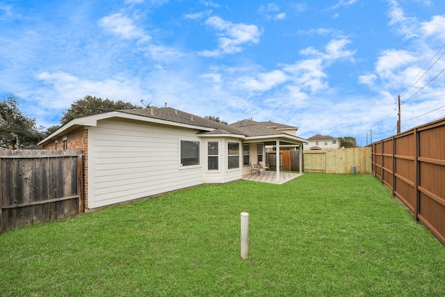 back of house with brick siding, a fenced backyard, a patio, and a yard