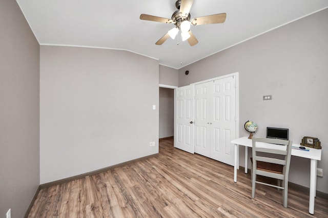 office space with ceiling fan, vaulted ceiling, wood finished floors, and baseboards