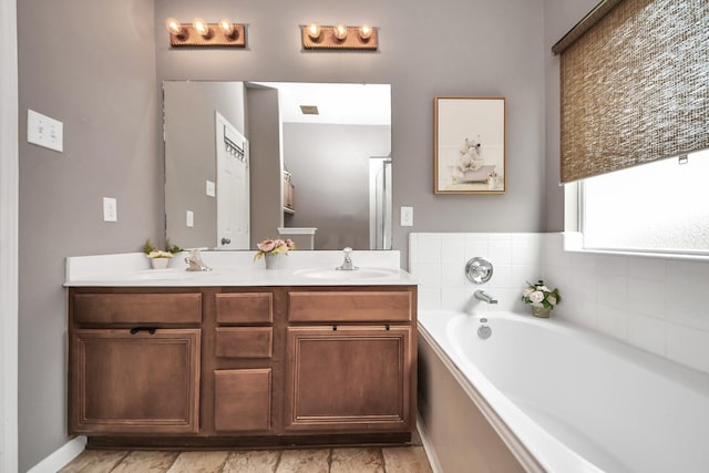 full bathroom featuring double vanity, a garden tub, visible vents, and a sink