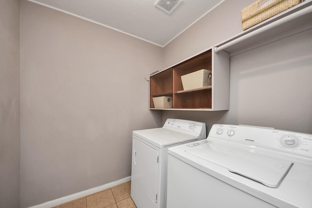 clothes washing area featuring light tile patterned flooring, laundry area, visible vents, baseboards, and washing machine and clothes dryer