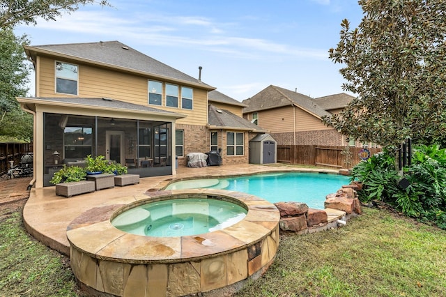 view of pool with a storage shed, a patio, a sunroom, a fenced backyard, and an in ground hot tub