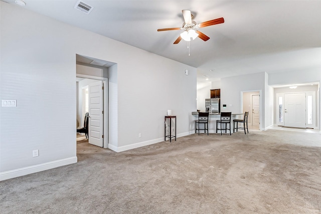 unfurnished living room featuring light colored carpet, visible vents, ceiling fan, and baseboards