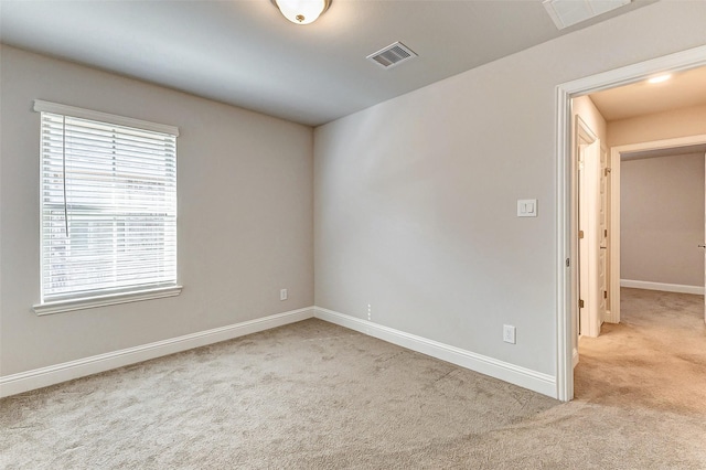 unfurnished room featuring carpet floors, baseboards, and visible vents