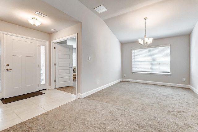 tiled foyer entrance with a notable chandelier, lofted ceiling, visible vents, carpet flooring, and baseboards