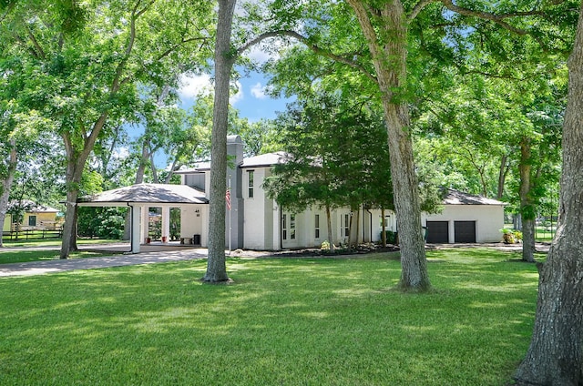 view of front of property featuring a garage, a chimney, a front lawn, and a gazebo