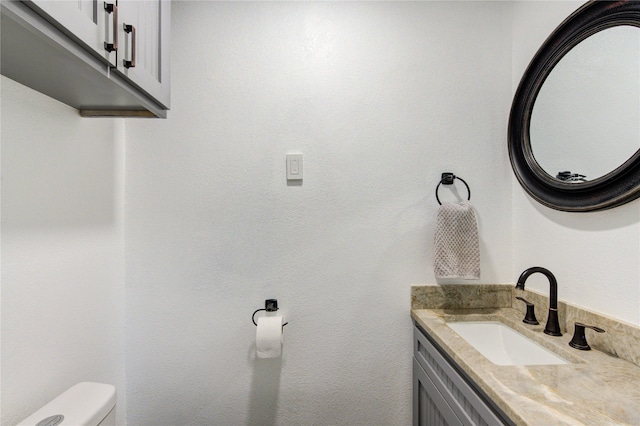 half bathroom with vanity and toilet