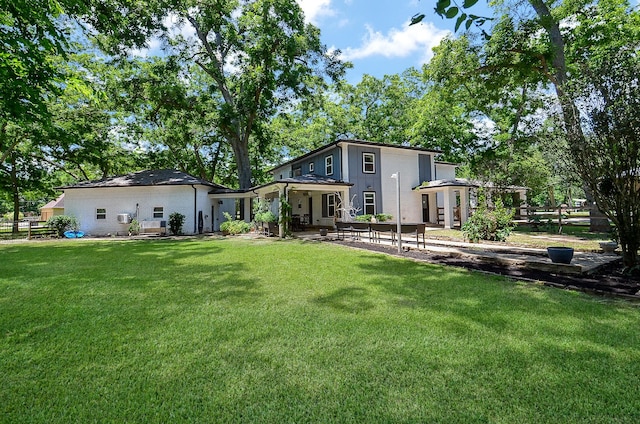 back of house with a lawn and a patio