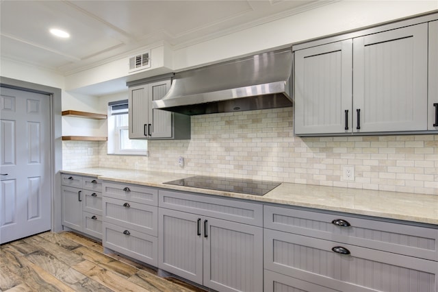 kitchen with wall chimney exhaust hood, black electric stovetop, and gray cabinets