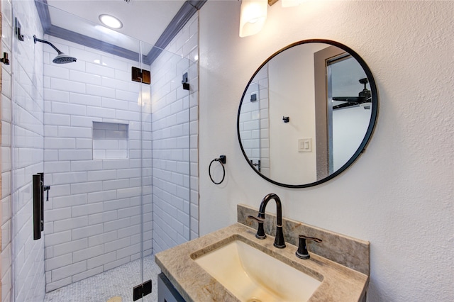 bathroom with a stall shower, a textured wall, and vanity